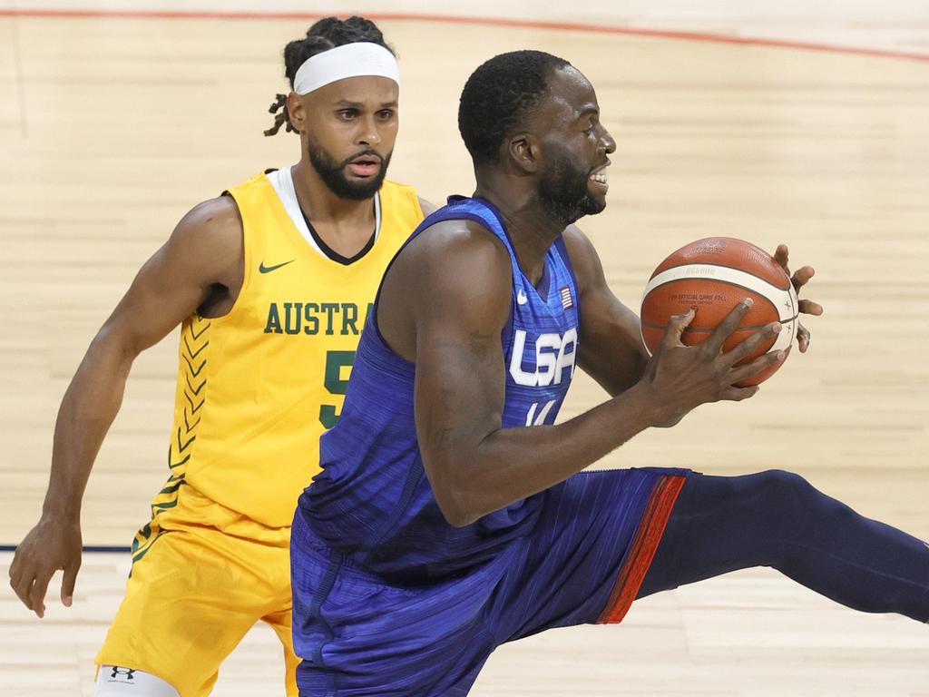 Patty Mills keeps his eye on Draymond Green.