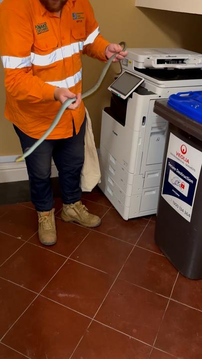 Brave worker sticks hand into printer, pulls out a snake