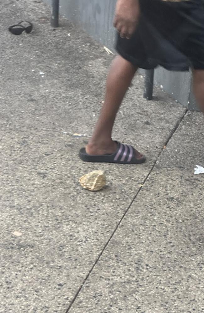 A man has been restrained by security guards outside the Cavenagh St Woolworths, Darwin, after allegedly throwing rocks at people.