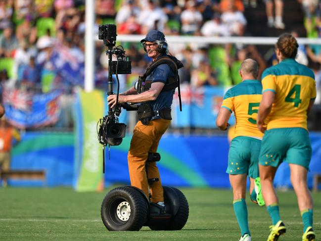 A cameraman films before the men’s rugby sevens match between Australia and Spain during the Rio 2016 Olympic Games at Deodoro Stadium in Rio de Janeiro on August 9, 2016. / AFP PHOTO / Pascal GUYOT