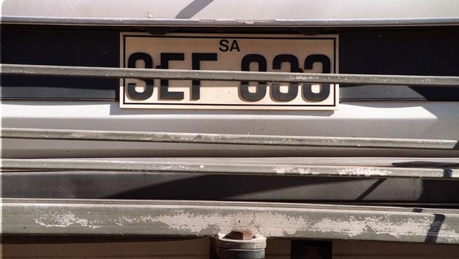 Motor car numberplate partly obscured by a bike rack.