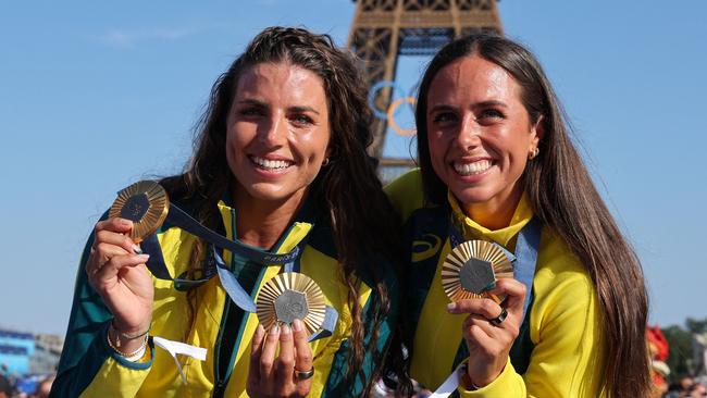 Australia's gold medallists and Jessica and Noemie Fox pose with their medals on stage at the Champions Park at Trocadero during the Paris 2024 Olympic Games in Paris on August 6, 2024, with the Eiffel Tower visible in the background. (Photo by Jack GUEZ / AFP)