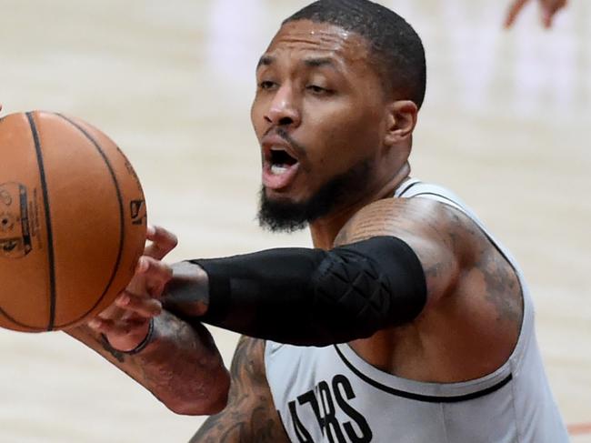 PORTLAND, OREGON - MARCH 16: Damian Lillard #0 of the Portland Trail Blazers reaches for the ball and fouls Brandon Ingram #14 of the New Orleans Pelicans during the first half of the game at Moda Center on March 16, 2021 in Portland, Oregon. NOTE TO USER: User expressly acknowledges and agrees that, by downloading and or using this photograph, user is consenting to the terms and conditions of the Getty Images License Agreement.   Steve Dykes/Getty Images/AFP == FOR NEWSPAPERS, INTERNET, TELCOS & TELEVISION USE ONLY ==