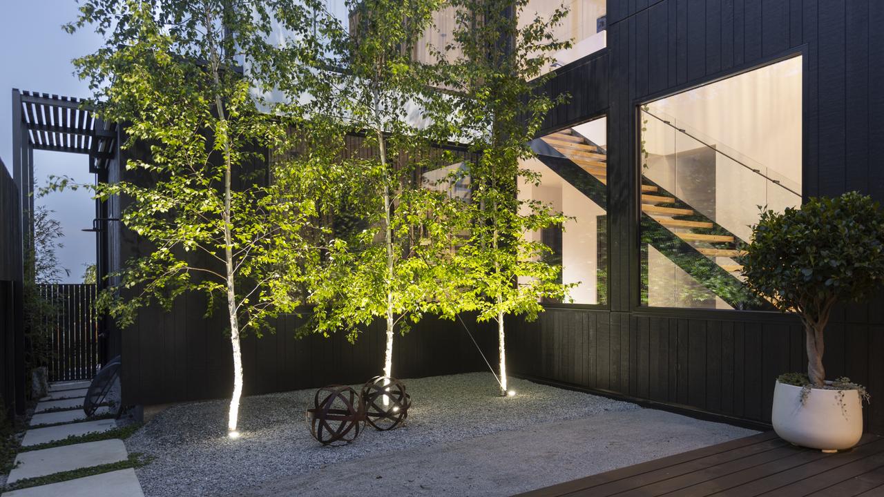 A bold black timber and concrete facade makes a striking statement for potential buyers.