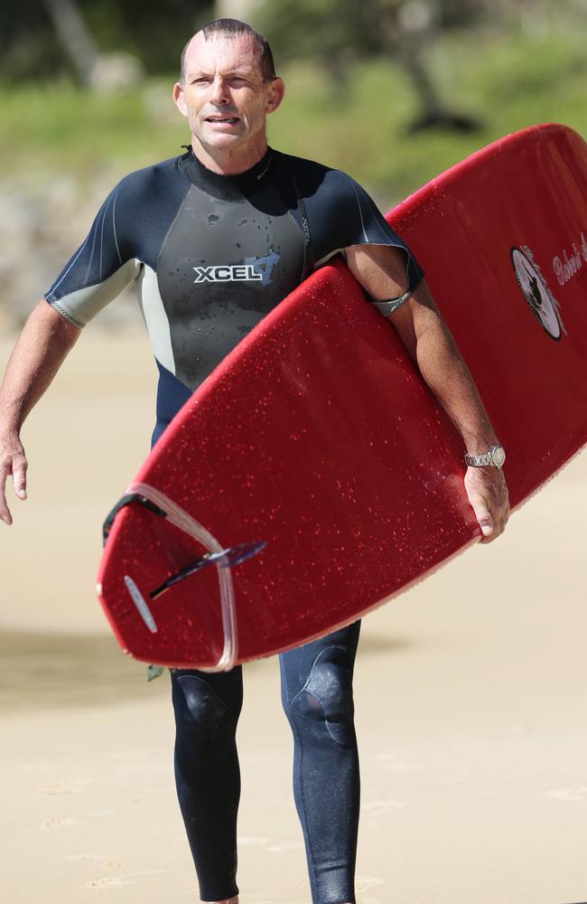 Former Prime Minister Tony Abbott walks the beach after surfing at Tea Tree Bay in the Noosa National Park. Picture: Lachie Millard