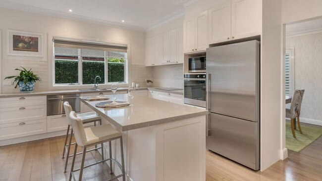 The kitchen has stone benchtops, a Fisher &amp; Paykel four-burner induction cooktop, wall oven, dishwasher and a central island bench and breakfast bar.