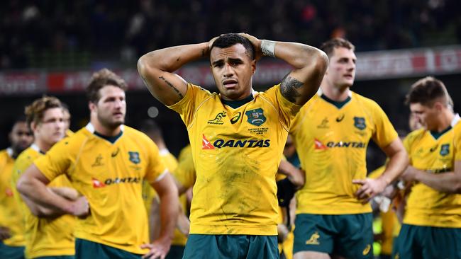 Will Genia of Australia stands dejected among his teammates following their defeat.