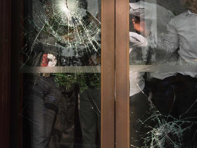 Members of the South African parliament security forces hold a door with broken windows closed as Economic Freedom Fighters (EFF) party members try to break their way back into the building after being physically removed from the South African parliament. Picture: AFP