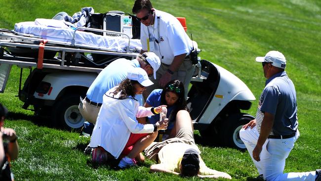 Christopher Crawford's caddie gets medical attention after injuring himself during a practice round prior to the US Open at Oakmont Country Club.