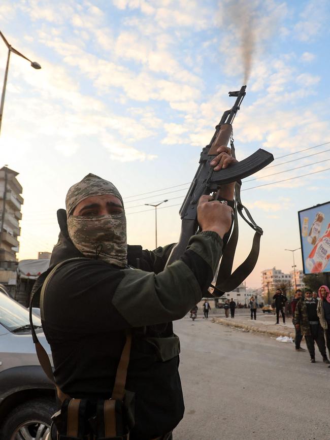 A Syrian anti government fighter fires his rifle into the air in the streets of the west-central city of Hama. Picture: Abdulaziz Ketaz/AFP