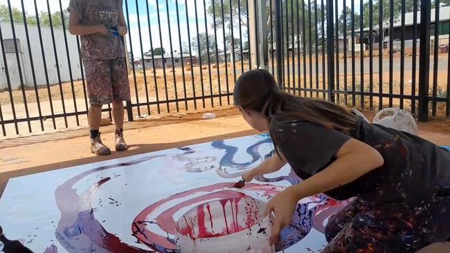 Stills taken from video footage obtained by The Weekend Australian shows Rosie Palmer, manager of Tjala Art in the APY Lands settlement of Amata, contributing to a painting by Indigenous artist Yaritji Young.