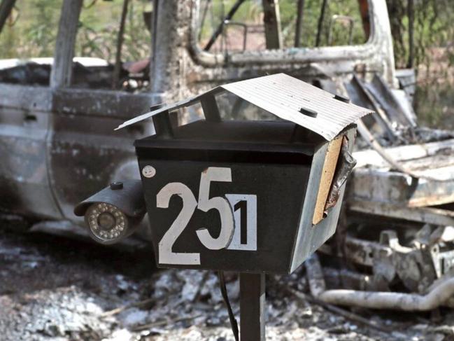 A burnt out car at the entrance to the property.