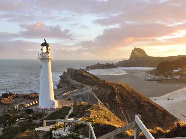 Dramatic golden sunset beams illuminate the Castle Point Lighthouse - it is near the village of Castlepoint in the Wellington Region of the North Island of New Zealand.