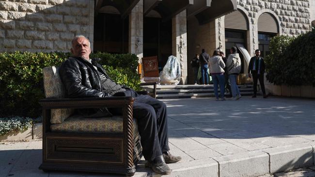 A man sits in an armchair outside of the Tishrin residential palace of Syria's ousted dictator Bashar al-Assad in Damascus. Picture: AFP