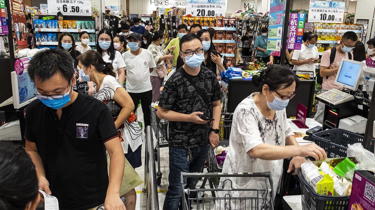 People wear protective masks as they line up to pay in a supermarket. Picture: Getty Images.