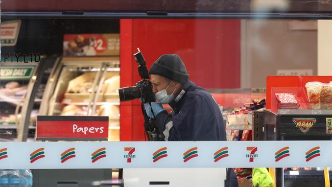 An investigator photographs the crime scene. Picture: David Crosling