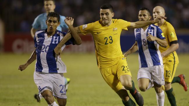 Tom Rogic tries to muscle his way past the Honduras defence.