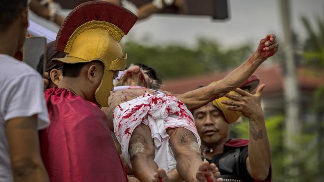 Penitent Wilfredo Salvador is removed from a cross after being crucified during Good Friday on April 7, 2023 in San Fernando, Pampanga, Philippines.