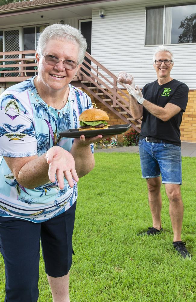 Audrey Preddy with a hamburger made from burger patties delivered to her Kenmore home by Michael Pulvirenti from BGR PL8 Jindalee. Picture: Richard Walker/AAP