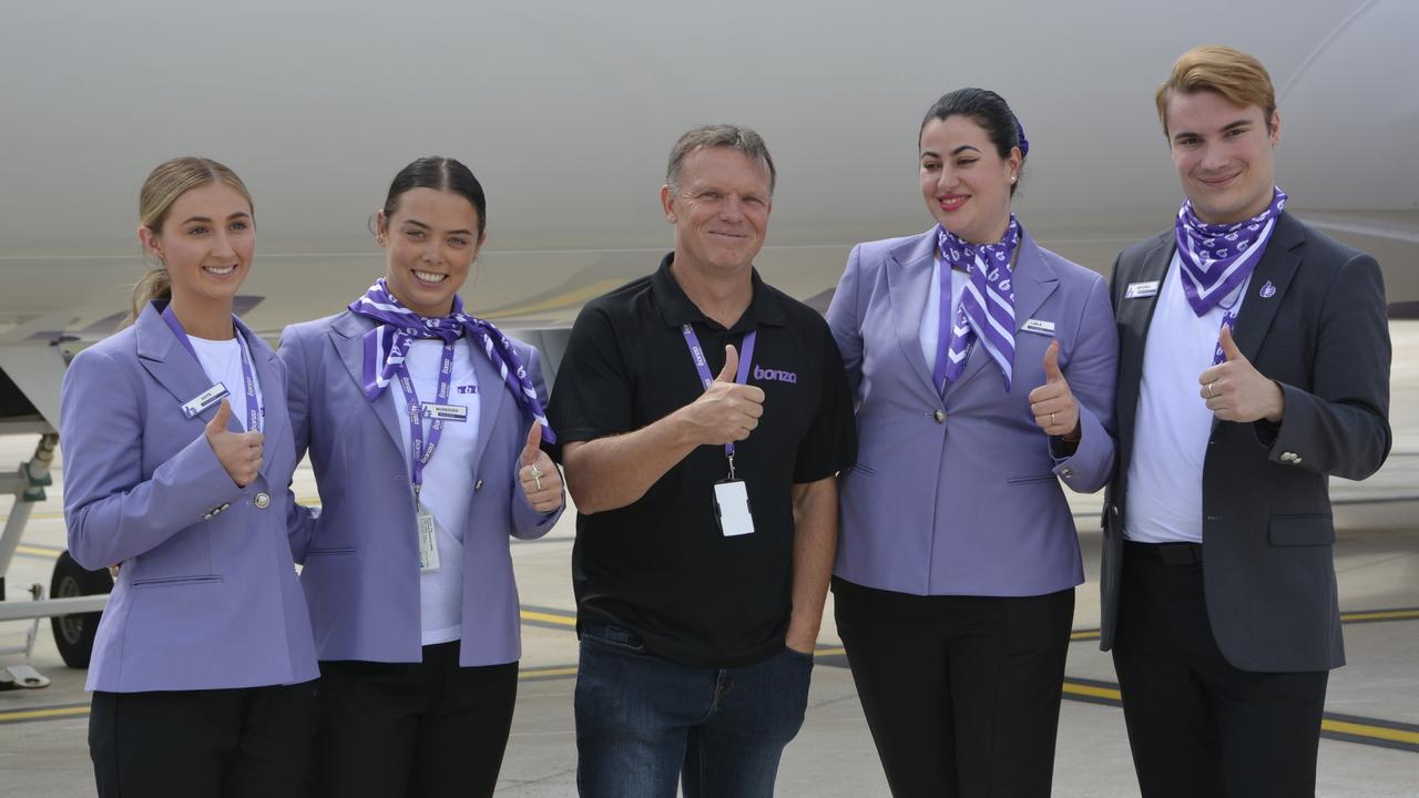 Bonza CEO Tim Jordan (centre) with members of the cabin crew at the first flight by the carrier from Melbourne to Toowoomba Wellcamp Airport.