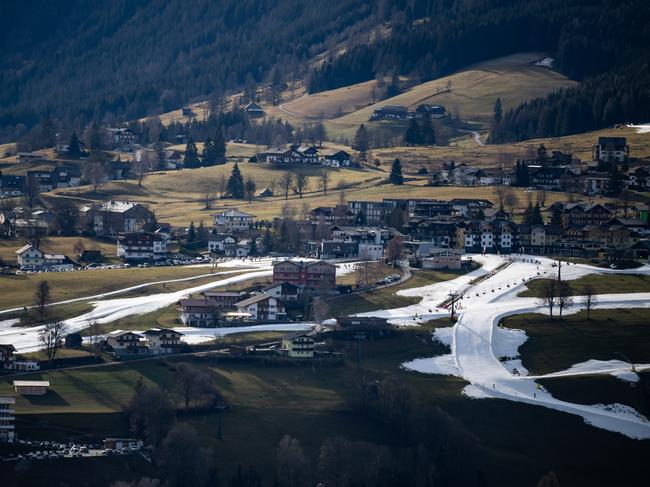 Skiers descend the slopes of the Rohrmoos skiing area covered in artificial snow as grass covers the rest of the hill in Schladming, Austria. Picture: Daniel Kopatsch/Getty Images