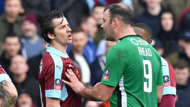 Burnley's English midfielder Joey Barton (L) talks with Lincoln City's English striker Matt Rhead.