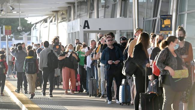 Travellers line up outside the domestic terminal at Sydney Airport on Saturday morning. Picture: Jeremy Piper