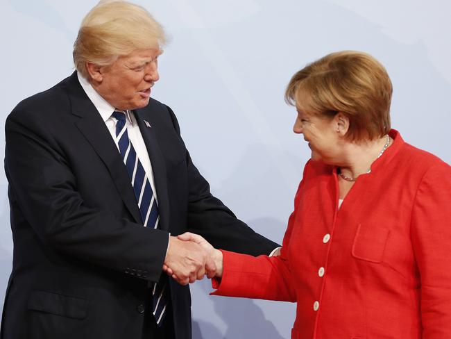 Donald Trump greets Angela Merkel at the start of the summit before clenching his fist while walking off. Picture: Friedemann Vogel — Pool/Getty Images