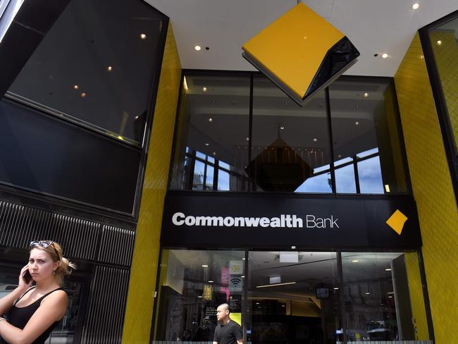 People walk past a branch of the Commonwealth Bank in Melbourne on February 6, 2019. - Australia's largest financial firm Commonwealth Bank on February 6 said profits fell six percent in the last six months of 2018 amid a "challenging environment" for the business. (Photo by William WEST / AFP)