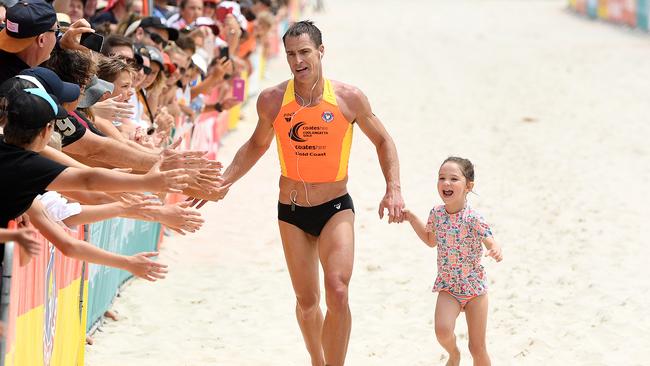 Shannon Eckstein finishes the final stretch of the Coolangatta Gold ironman race with daughter Ellie in 2017. (AAP Image/Dave Hunt) NO ARCHIVING