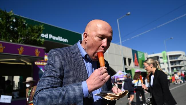 Peter Dutton eats a Dagwood Dog on People’s Day at the Ekka. Picture: NCA NewsWire / Dan Peled