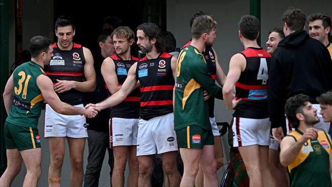 VAFA: Old Trinity and Old Xaverians players shake hands after the match was called off. Picture: Andy Brownbill