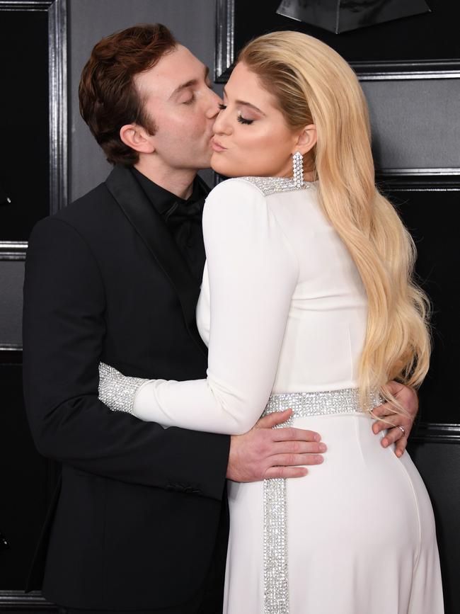 US singer Meghan Trainor and husband actor Daryl Sabara kiss on the Grammys red carpet. Picture: Getty