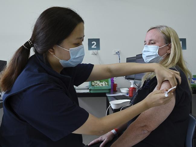 Zoe Leung delivers a vaccination to Fiona Paine in Sydney. Picture: Kate Geraghty/Pool