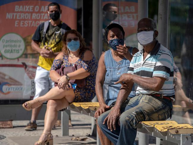 Locals wearing face masks wait for a bus during the first day of lockdown due to the COVID-19 in Rio de Janeiro. Picture: AFP