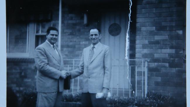 Mr Wain (right) shaking hands with 20th Century Fox executive Ray Marks after signing the first contract to screen films at The Savoy Theatre in 1956. Picture: courtesy of the Wain family.