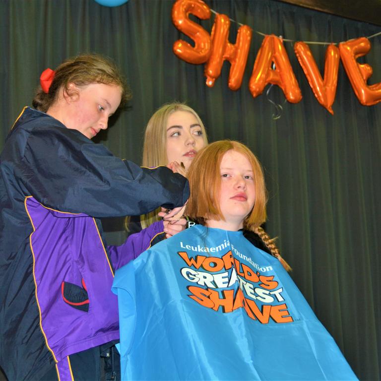 At the St Joseph's College 2023 World's Greatest Shave event is student Ellie Stagg having her hair cut by (from left) a friend and hairdresser Abbey McGaw from the Hair Room on Russell St. Picture: Rhylea Millar