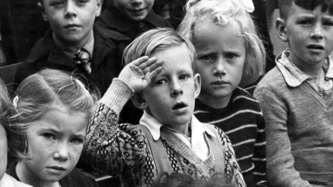 A student salutes during an Anzac Day ceremony at Windsor State School in Hornby St.