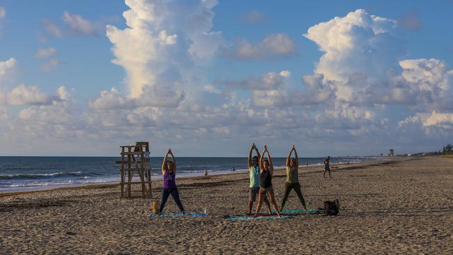 People doing yoga on the beach on Saturday in Melbourne, Florida. Picture: Saul Martinez