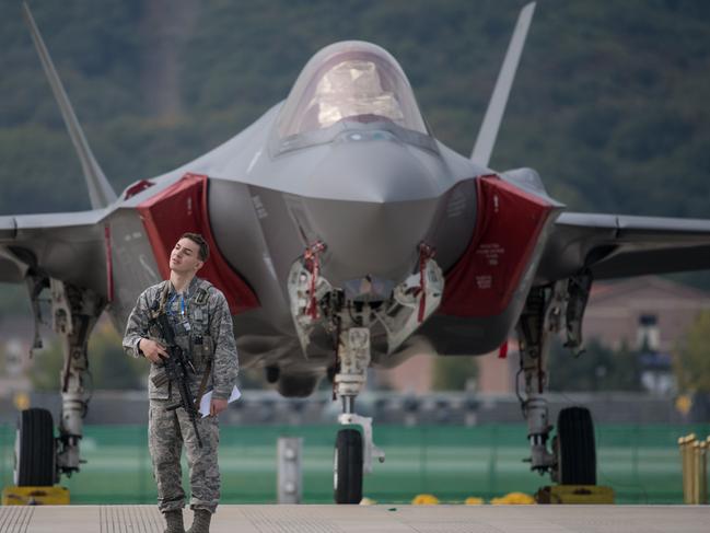 A US soldier guards a US F35 stealth aircraft at the Seoul International Aerospace and Defense Exhibition (ADEX) in Seongnam, south of Seoul, on October 16, 2017.  The six-day event runs from October 17 - 22, bringing together foreign and domestic aerospace and defence companies. South Korea's defence burgeoning exports industry has grown 1,100 per cent since 2009 as the nation’s arms manufacturers thrive off growing global instability, according to a report by the Financial Times.  / AFP PHOTO / Ed JONES