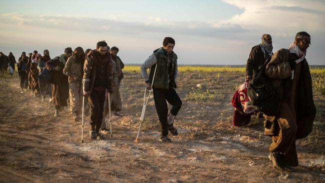 Suspected Islamic State fighters emerge from Baghouz. Picture: AFP