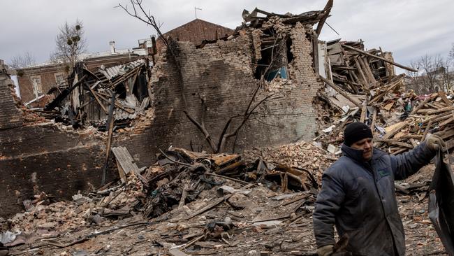 A volunteer clears away rubble from the front of a building that was destroyed by a Russian attack in Kharkiv, Ukraine. Picture: Getty Images