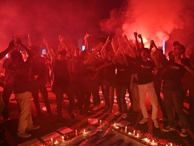 Football supporters named Ultras chant slogans during a candlelight vigil to show their condolences to victims of a stampede, in Jakarta. Picture: AFP