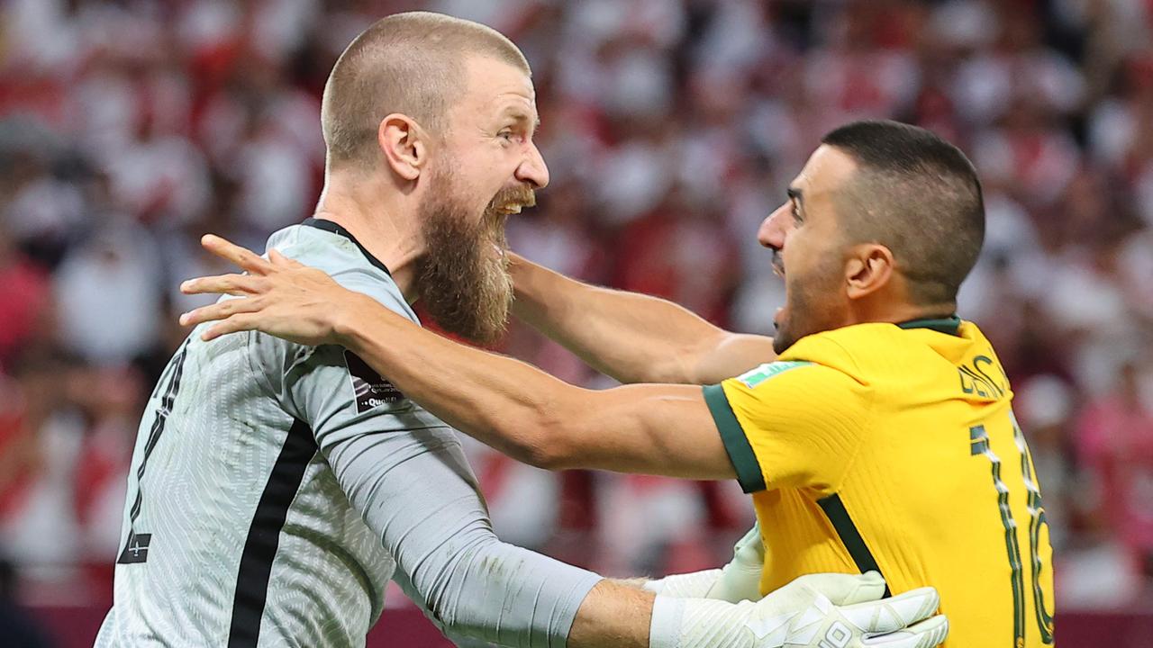 Australia's goalkeeper Andrew Redmayne (L) celebrates with Australia's defender Aziz Behich. Picture: KARIM JAAFAR/AFP