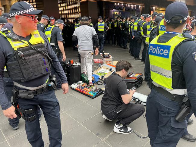 Police form a ring around a busker after a clash with pro-Palestine protesters in Bourke Street Mall. Picture: Fergus Ellis