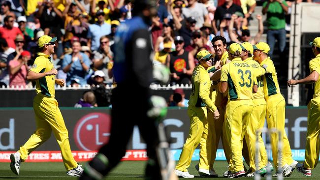 Brendon McCullum starts the long walk off the MCG pitch as Mitch Starc and Australia celebrate.