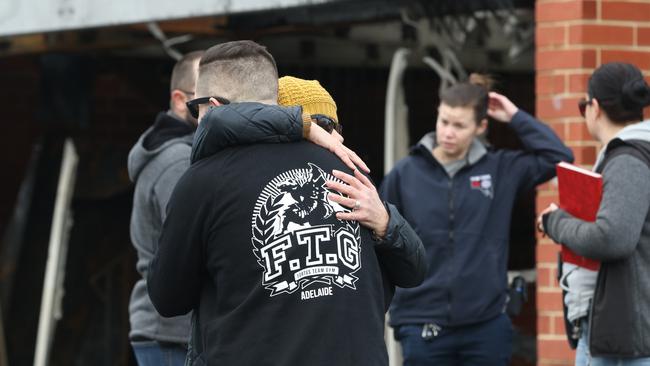 Fortus Team Gym head boxing coach Owen Hems is comforted outside his fire-damaged gym. Picture: AAP/Russell Millard