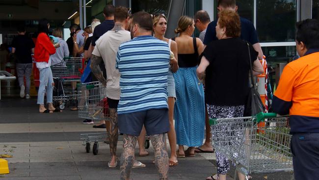 People queue outside Woolworths at Skygate, Brisbane, amid panic buying of groceries. Picture: David Clark