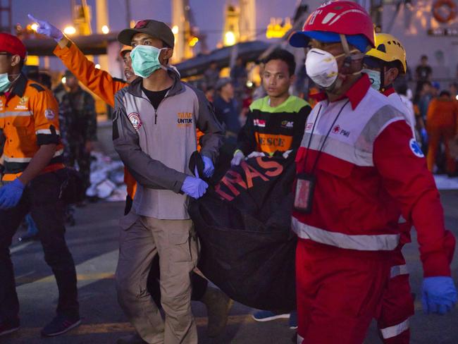 Search and rescue workers move the remains of a victim into a waiting ambulance at the Tanjung Priok port. Picture: Ed Wray/Getty Images