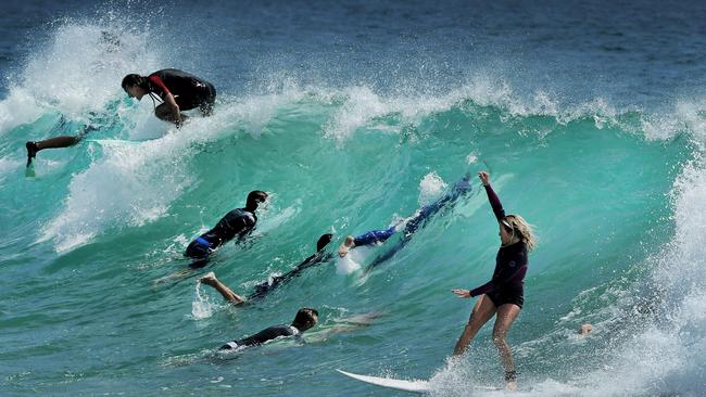 A surfer navigates a crowded line-up at Currumbin Alley. Pic by Luke Marsden.